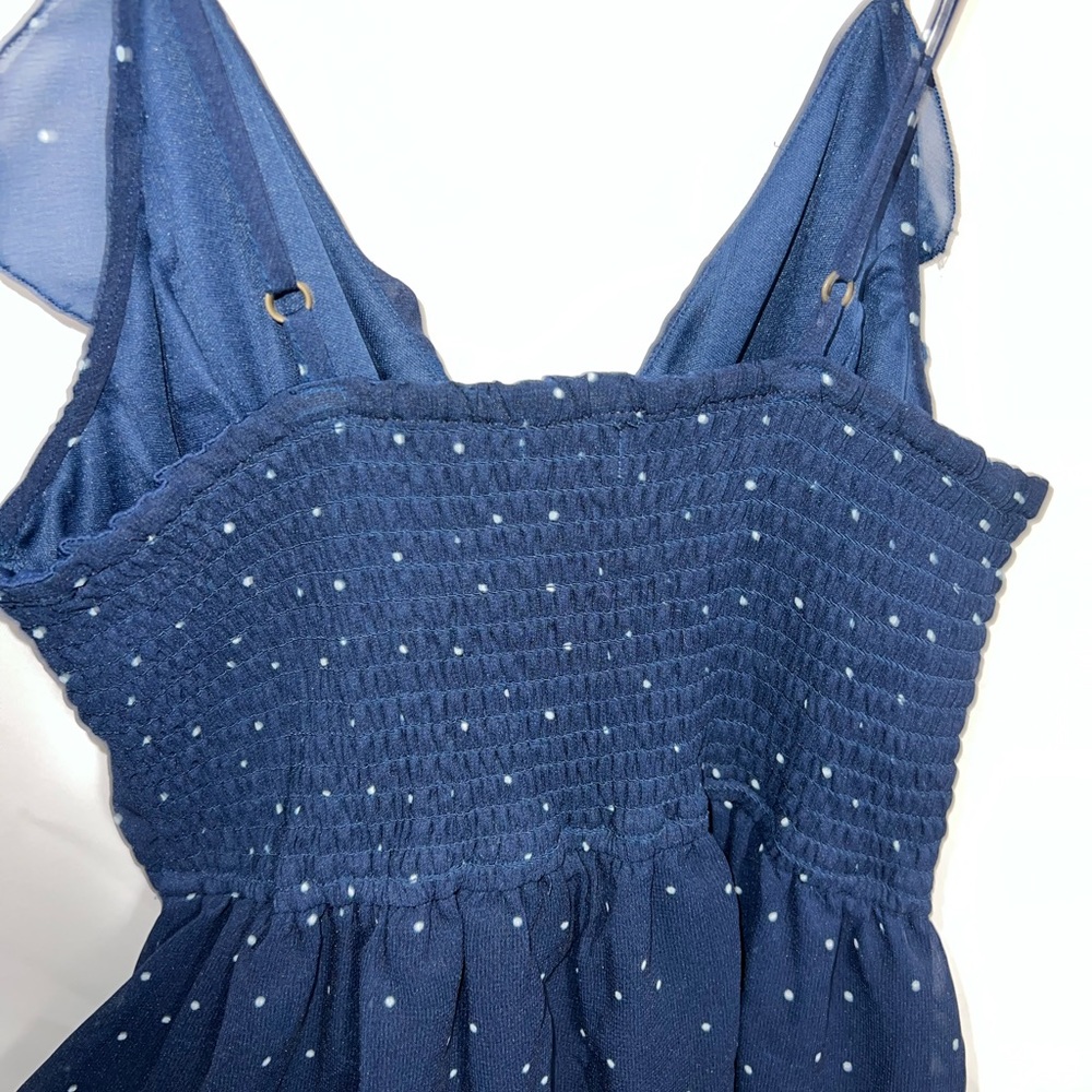 Navy blue with white dots women’s short romper with ruffle on the breast area.